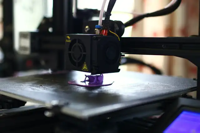 A print head lays down the first layers of a purple part