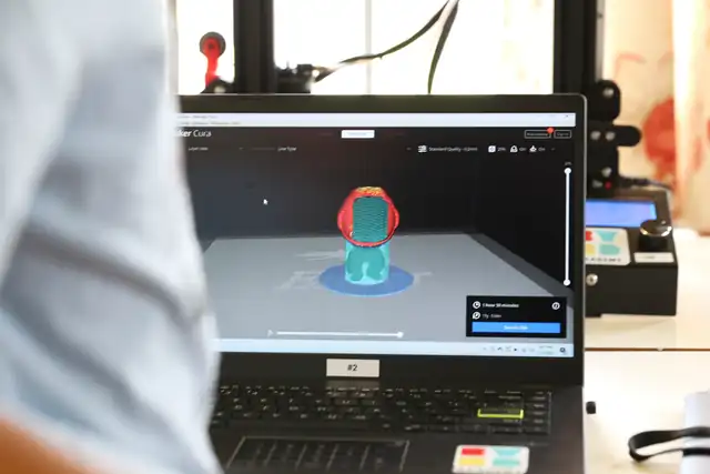 A model ready to slice on a laptop beside the printer